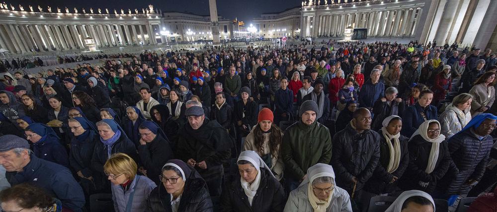 Gläubige beten während eines Rosenkranzgebets für die Gesundheit von Papst Franziskus auf dem Petersplatz.