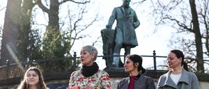 Kathy Herrmann Aguero (v.l.), Grünen Fraktion Neukölln, Susanna Kahlefeld, Sprecherin für Engagement und Beteiligung der Grünen Fraktion im Berliner Abgeordnetenhaus, Bahar Haghanipour, Frauenpolitische Sprecherin der Grünen Fraktion im Berliner Abgeordnetenhaus, und Bezirksstadträtin Janine Wolter (SPD) stehen vor einem Denkmal für Friedrich Ludwig Jahn.