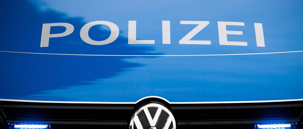 Ein Blaulicht leuchtet im Kühlergrill eines Polizeiwagens in Nahaufnahme. (Symbolbild)