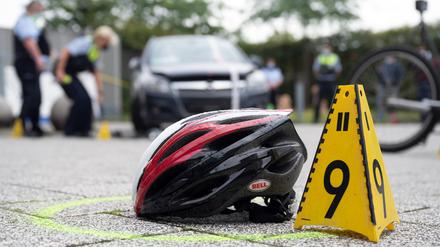 Ein Fahrradhelm liegt bei einer Verkehrsunfallaufnahme auf dem Boden. (Symbolbild)