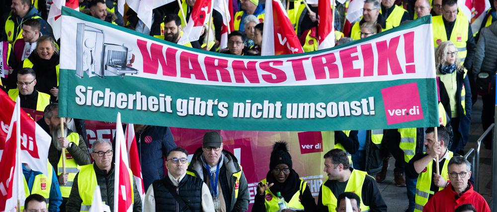 Verdi-Mitglieder ziehen beim Warnstreik in einem Protestzug durch das Terminal 1 im Flughafen Frankfurt.