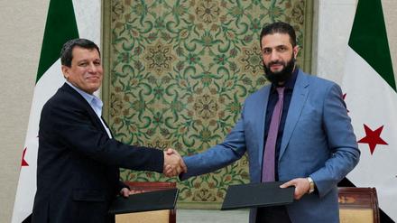 Der syrische Interimspräsident Ahmed al-Sharaa und Mazlum Abdi nach der Unterzeichnung des Abkommens.