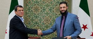 Der syrische Interimspräsident Ahmed al-Sharaa und Mazlum Abdi nach der Unterzeichnung des Abkommens.