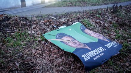Abgerissene Wahlplakate der Grünen mit Robert Habeck liegen neben einer Straße.