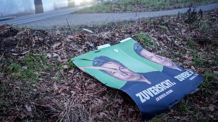 Abgerissene Wahlplakate der Grünen mit Robert Habeck liegen neben einer Straße.