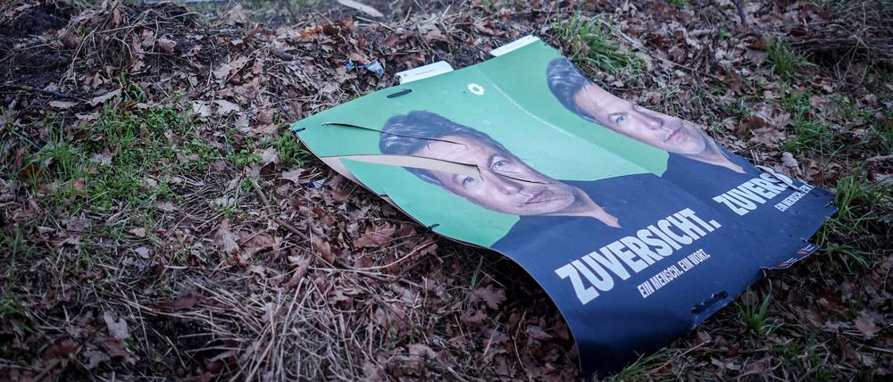 Abgerissene Wahlplakate der Grünen mit Robert Habeck liegen neben einer Straße.