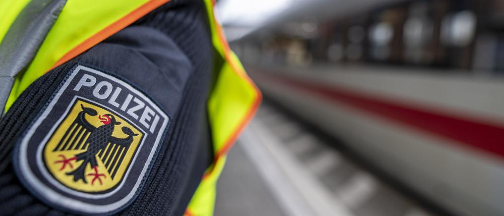 Ein Bundespolizist steht an einem Bahnhof vor einem ICE.