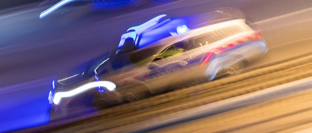 Symbolbild eines Polizeiwagens bei einer Einsatzfahrt mit Blaulicht.