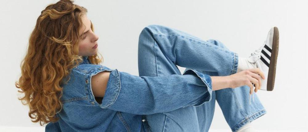 Ein rothaariges Model posiert in Denim-Kleidung der ukrainischen Marke Aisenberg.