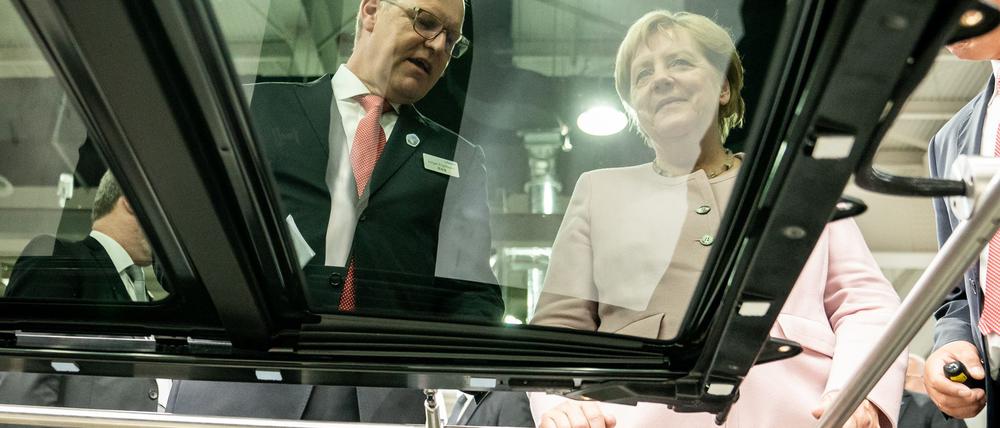 Der scheidende Webasto-Chef Holger Engelmann in besseren Tagen im Jahr 2019. Hier demonstriert der Manager der früheren Bundeskanzlerin Angela Merkel in einem Werk im chinesischen Wuhan die Fertigung von Schiebedächern.
