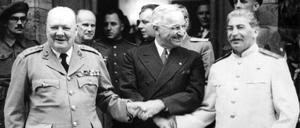 Der britische Premierminister Winston Churchill (l.), der amerikanische Präsident Harry S. Truman (M.) und der sowjetische Diktator Josef Stalin reichen sich während der Potsdamer Konferenz vor Schloss Cecilienhof die Hände.