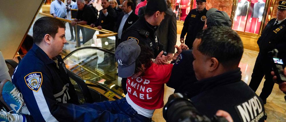 A demonstrators from the human rights organization Jewish Voice for Peace is detained by NYPD officers as they hold a civil disobedience action inside Trump Tower in New York on March 13, 2025. (Photo by TIMOTHY A. CLARY / AFP)