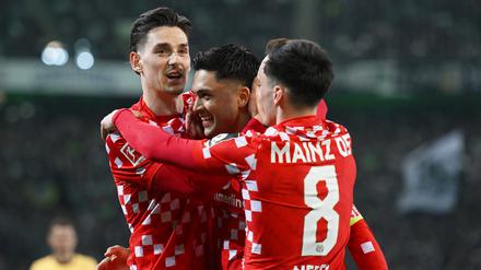 Es läuft. Die Mainzer Anthony Caci (l-r), Nadiem Amiri und Paul Nebel feiern über ein Tor. 