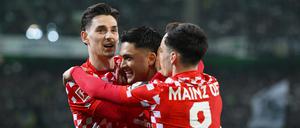 Es läuft. Die Mainzer Anthony Caci (l-r), Nadiem Amiri und Paul Nebel feiern über ein Tor. 