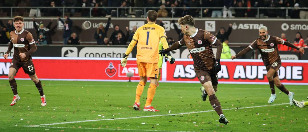 Nach dem Missgeschick wendet sich Hoffenheims Torwart Oliver Baumann (2.v.l) mit Schrecken von St. Paulis Torjubel ab.