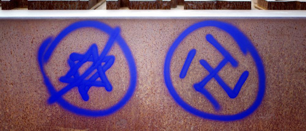 Ein Hakenkreuz und ein durchgestrichener Davidstern sind an einer Gedenkstätte am Nordbahnhof in Berlin zu sehen.