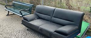 Unbekannte haben in Berlin-Wilmersdorf ein altes Sofa neben eine Sitzbank gestellt.