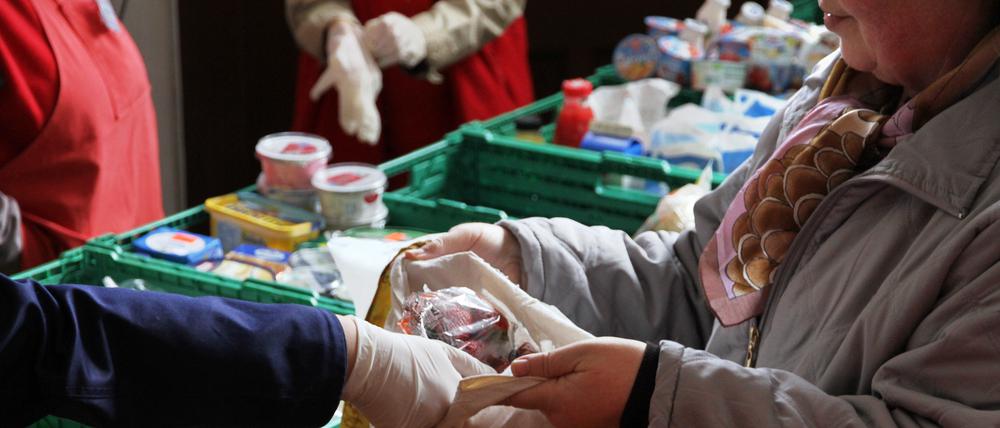 Eine Mitarbeiterin der Berliner Tafeln verteilt Obst an Bedürftige. 