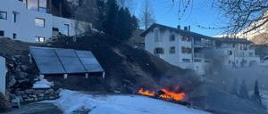 Trümmer brennen an der Absturzstelle eines Kleinflugzeugs in La Punt Chamues-ch in der Schweiz.