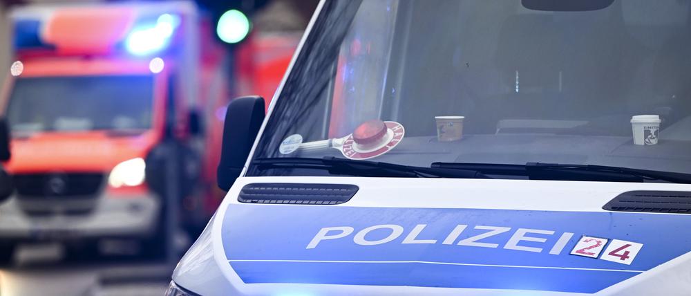 Ein Polizeiauto und ein Rettungswagen mit Blaulicht. 