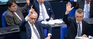 Friedrich Merz (l.) stimmt im Rahmen der Debatte um die Grundgesetzänderung am Dienstag gemeinsam mit seiner CDU-Fraktion.