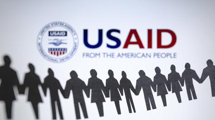 ARCHIV - 04.02.2025, Paraguay, Asunción: Das Logo der US-Entwicklungsbehörde, United States Agency for International Development (USAID), ist hinter einer Kette von ausgeschnittenen Papierfiguren zu sehen. (zu dpa: «Gericht: USAID-Auflösung wahrscheinlich verfassungswidrig») Foto: Andre M. Chang/ZUMA Press Wire/dpa +++ dpa-Bildfunk +++