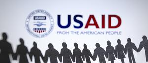 ARCHIV - 04.02.2025, Paraguay, Asunción: Das Logo der US-Entwicklungsbehörde, United States Agency for International Development (USAID), ist hinter einer Kette von ausgeschnittenen Papierfiguren zu sehen. (zu dpa: «Gericht: USAID-Auflösung wahrscheinlich verfassungswidrig») Foto: Andre M. Chang/ZUMA Press Wire/dpa +++ dpa-Bildfunk +++