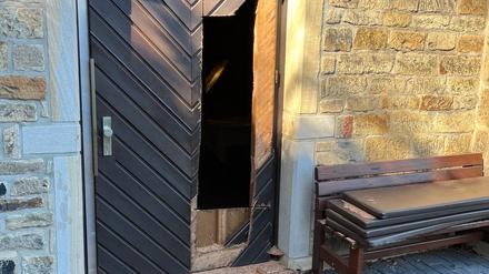 Holz der beschädigten Seitentür einer Kirche liegt auf dem Boden. Mit einer Kettensäge soll ein unbekannter Einbrecher sich am helllichten Tag Zutritt zum Gotteshaus verschafft haben.