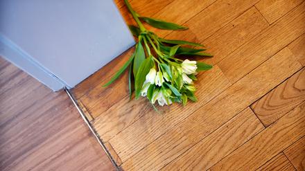 Blumen liegen auf dem Boden vor dem Zimmer eines Verstorbenen (Symbolbild).