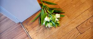 Blumen liegen auf dem Boden vor dem Zimmer eines Verstorbenen (Symbolbild).