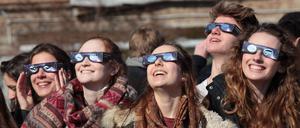 Junge Menschen betrachten eine Sonnenfinsternis 2015 in Potsdam. 