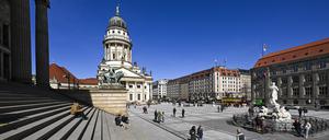 Bei Sonnenschein sind zahlreiche Menschen auf dem Gendarmenmarkt mit dem Konzerthaus (l) und dem Französischen Dom unterwegs. 