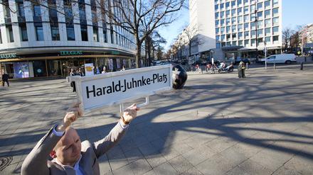 Felix Recke-Friedrich (FDP), Fraktionsvorsitzender in der Bezirksverordnetenversammlung Charlottenburg-Wilmersdorf, steht mit einem Straßenschild und der Aufschrift «Harald-Juhnke-Platz» an der Straßenecke Kurfürstendamm/Uhlandstraße/Grolmanstraße. 