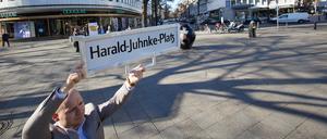 Felix Recke-Friedrich (FDP), Fraktionsvorsitzender in der Bezirksverordnetenversammlung Charlottenburg-Wilmersdorf, steht mit einem Straßenschild und der Aufschrift «Harald-Juhnke-Platz» an der Straßenecke Kurfürstendamm/Uhlandstraße/Grolmanstraße. 