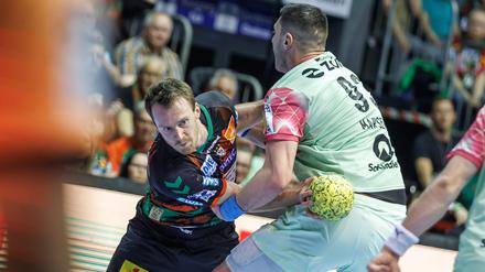 Felix Claar von SC Magdeburg wird festgemacht von Berlins Mijajlo Marsenic (r). 