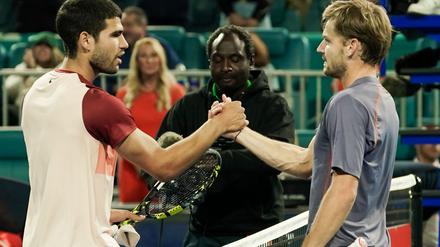 Carlos Alcaraz (l) gratuliert dem Außenseiter David Goffin für dessen Überraschungscoup.