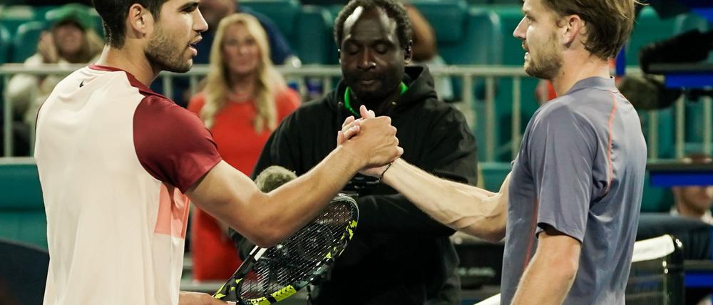 Carlos Alcaraz (l) gratuliert dem Außenseiter David Goffin für dessen Überraschungscoup.