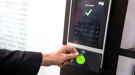 Ein Mitarbeiter erfasst seine Arbeitszeit digital an einem Terminal.