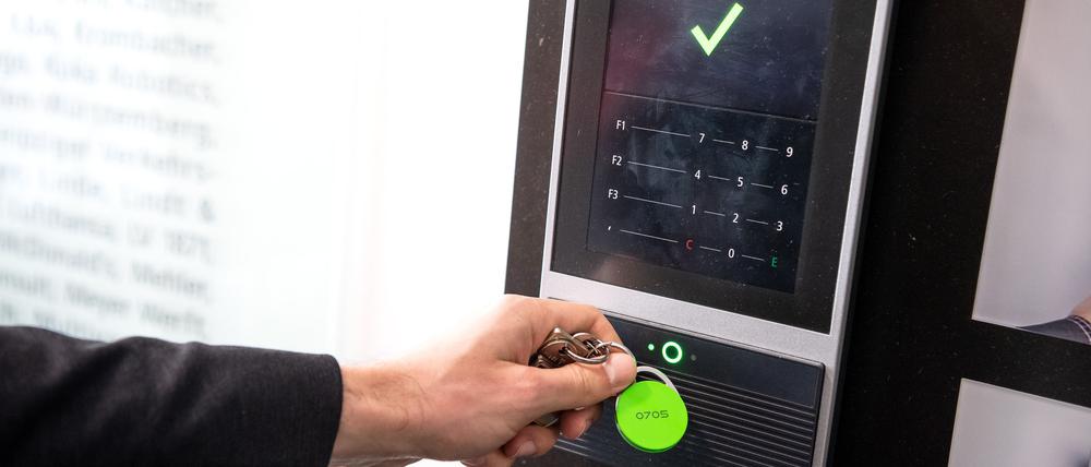Ein Mitarbeiter erfasst seine Arbeitszeit digital an einem Terminal.