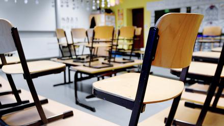 Stühle stehen in einem Klassenzimmer in einer Grundschule auf den Tischen.
