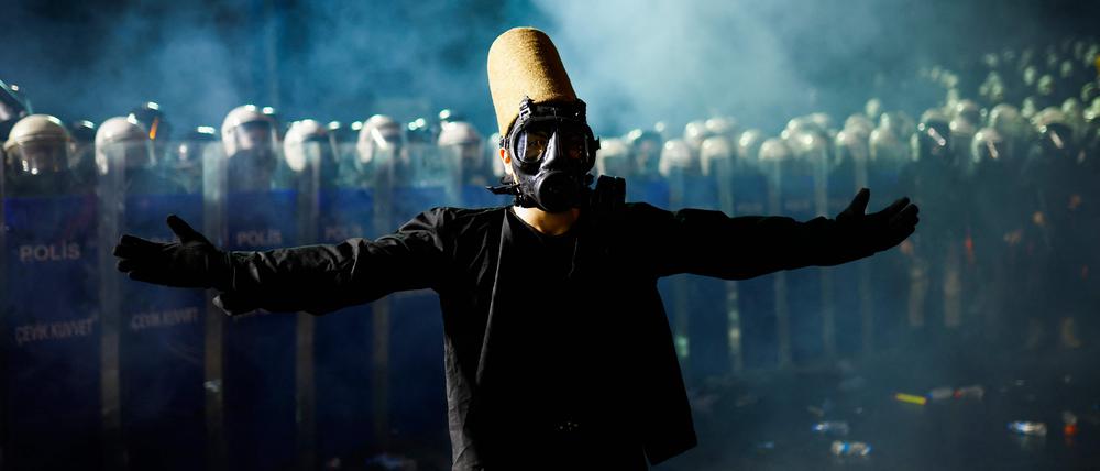 Ein wirbelnder Derwisch steht vor der türkischen Bereitschaftspolizisten während einer Kundgebung zur Unterstützung des verhafteten Bürgermeisters Imamoglu.