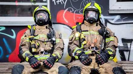 Feuerwehrleute ruhen sich nach einem Einsatz in der Czeminskistraße in Berlin-Schöneberg aus. 