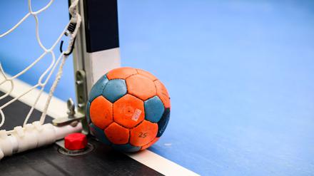 Ein Handball liegt neben einem Torpfosten.