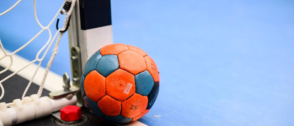 Ein Handball liegt neben einem Torpfosten.