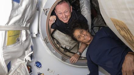 Die Astronauten Barry „Butch“ Wilmore (l.) und Suni Williams posieren vor der ISS.