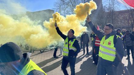 Mit Rauchtöpfen demonstrieren Beschäftigte der Berliner Verkehrsbetriebe (BVG)vor dem Roten Rathaus in Berlin. 
