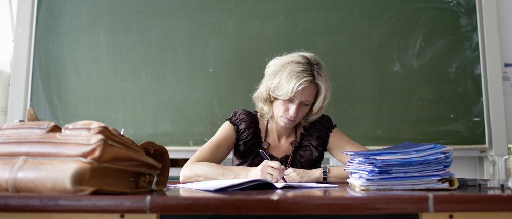 Lehrerin korrigiert Hefte im Klassenzimmer.