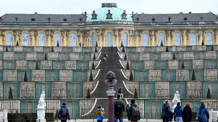 Besucher erklimmen die Treppen zum Schloss Sanssouci. 