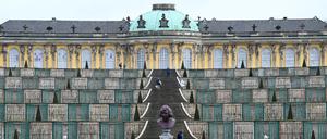 Besucher erklimmen die Treppen zum Schloss Sanssouci. 