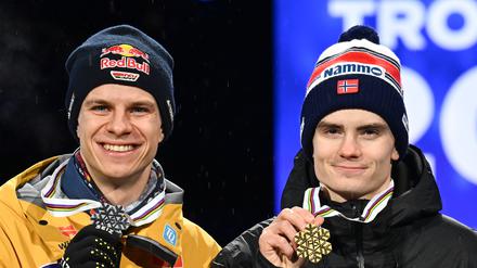 Marius Lindvik (rechts) aus Norwegen zeigt seine Goldmedaille neben Andreas Wellinger.